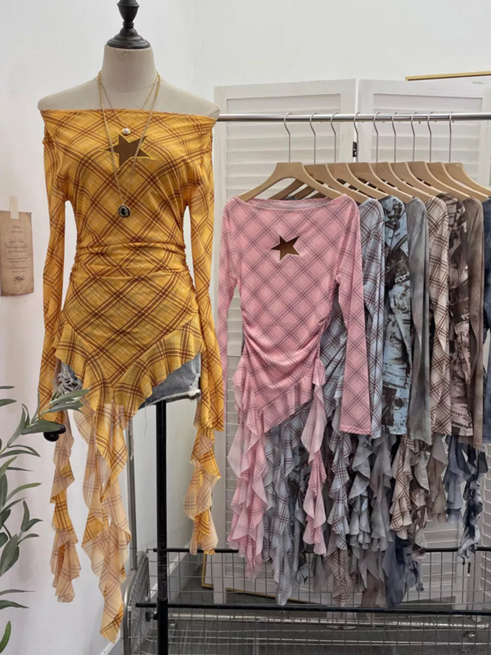 Yellow plaid asymmetrical ruffle hem t-shirt with star cutout, off-the-shoulder neckline and long sleeves.