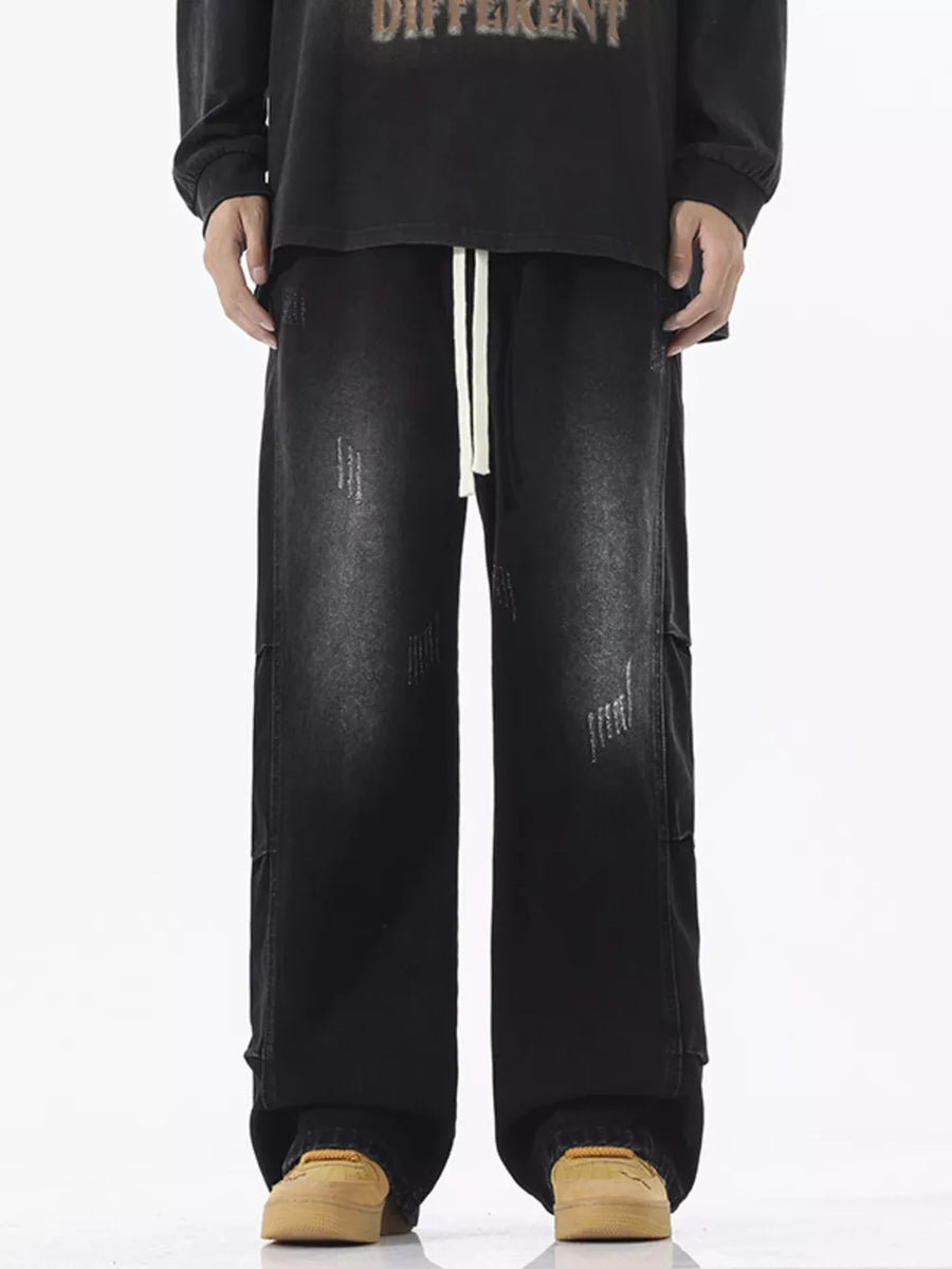 Black oversized vintage wash wide leg jeans with distressed details and drawstring waist.