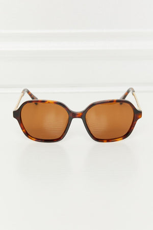 Brown tortoiseshell hexagonal frame sunglasses with gold accents on temples.