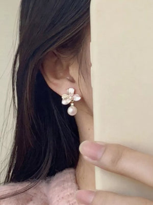 Charming pearl blossom drop earrings with delicate petals and a single pearl.