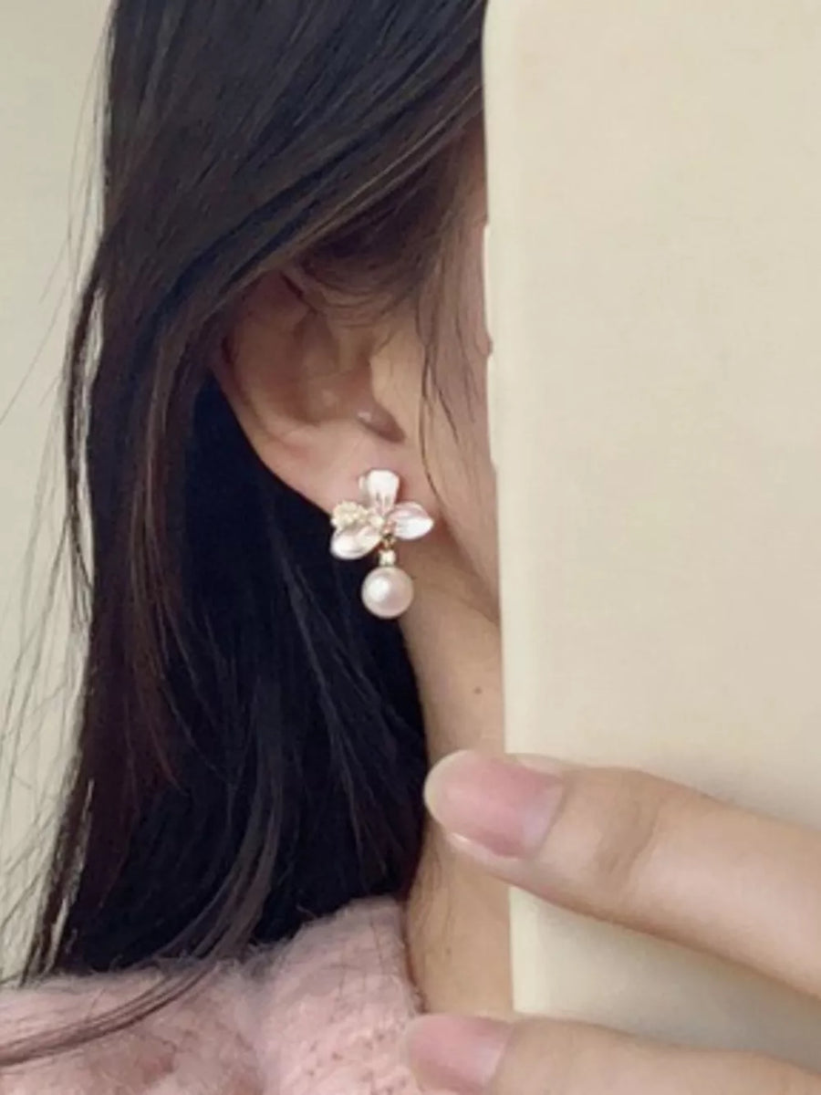 Charming pearl blossom drop earrings with delicate petals and a single pearl.