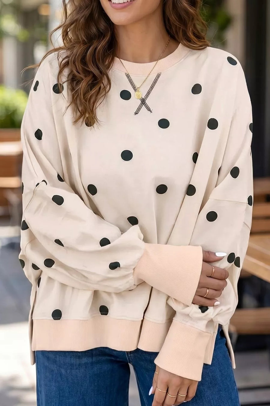 black tunic featuring ribbed cuffs and polka dot