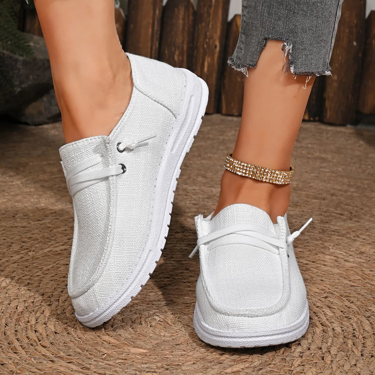 White linen-blend boat shoes with contrast sole and decorative laces.