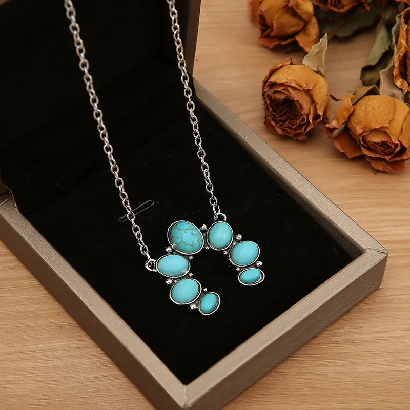Turquoise horseshoe necklace with silver chain and alloy setting.