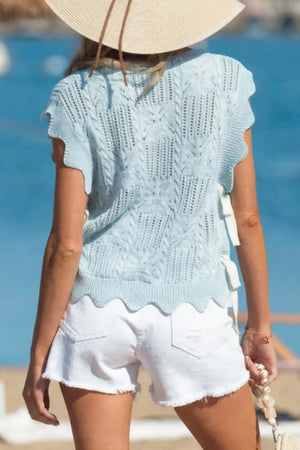 Light blue cable-knit openwork cardigan with cap sleeves and scalloped hem.