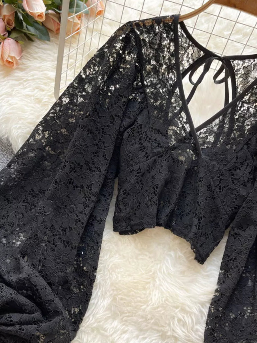 Black sheer floral lace cropped shirt with balloon sleeves and tie-back detail.