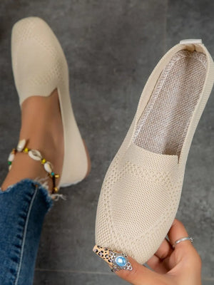 Beige knit ballet flats with diamond pattern detail.