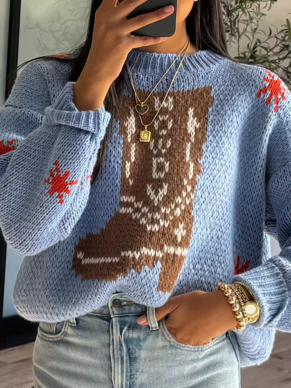 Light blue acrylic knit jumper with a brown and white intarsia western boot design and red accents.