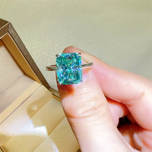 Emerald cut moissanite ring in silver with architectural design and bright brilliance.
