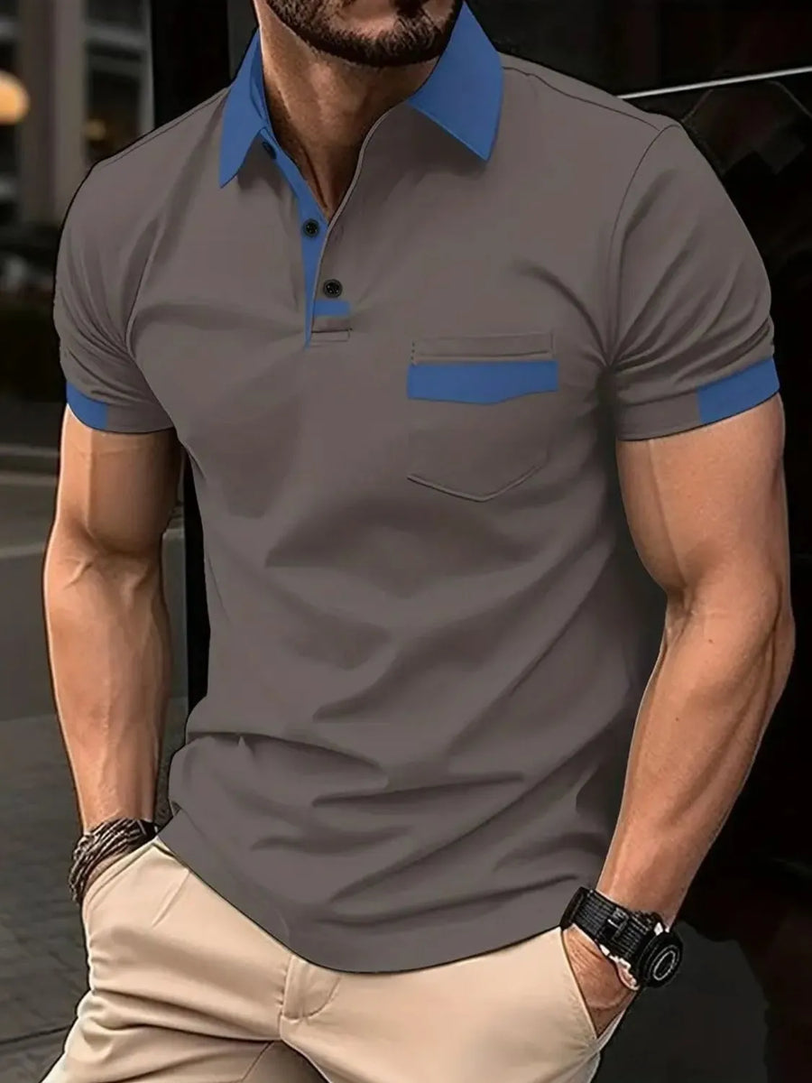 Color-blocked polo shirt in grey with blue collar, pocket detail, and sleeve trim.