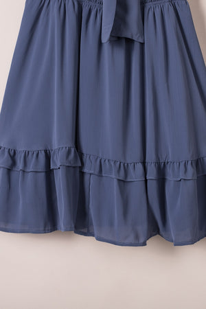 Dusty blue ruffled mini dress with a bow-tie V-neck and tiered hem.