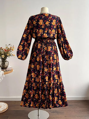 Maxi dress with V-neck, long balloon sleeves, and tiered skirt in a dark floral print.