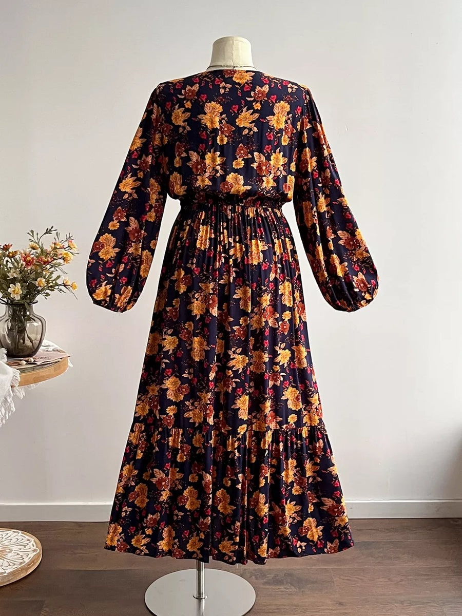 Maxi dress with V-neck, long balloon sleeves, and tiered skirt in a dark floral print.