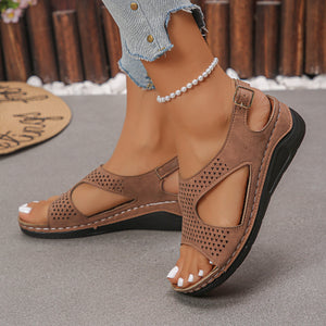 Brown cutout wedge sandals with adjustable ankle strap and perforated detail.