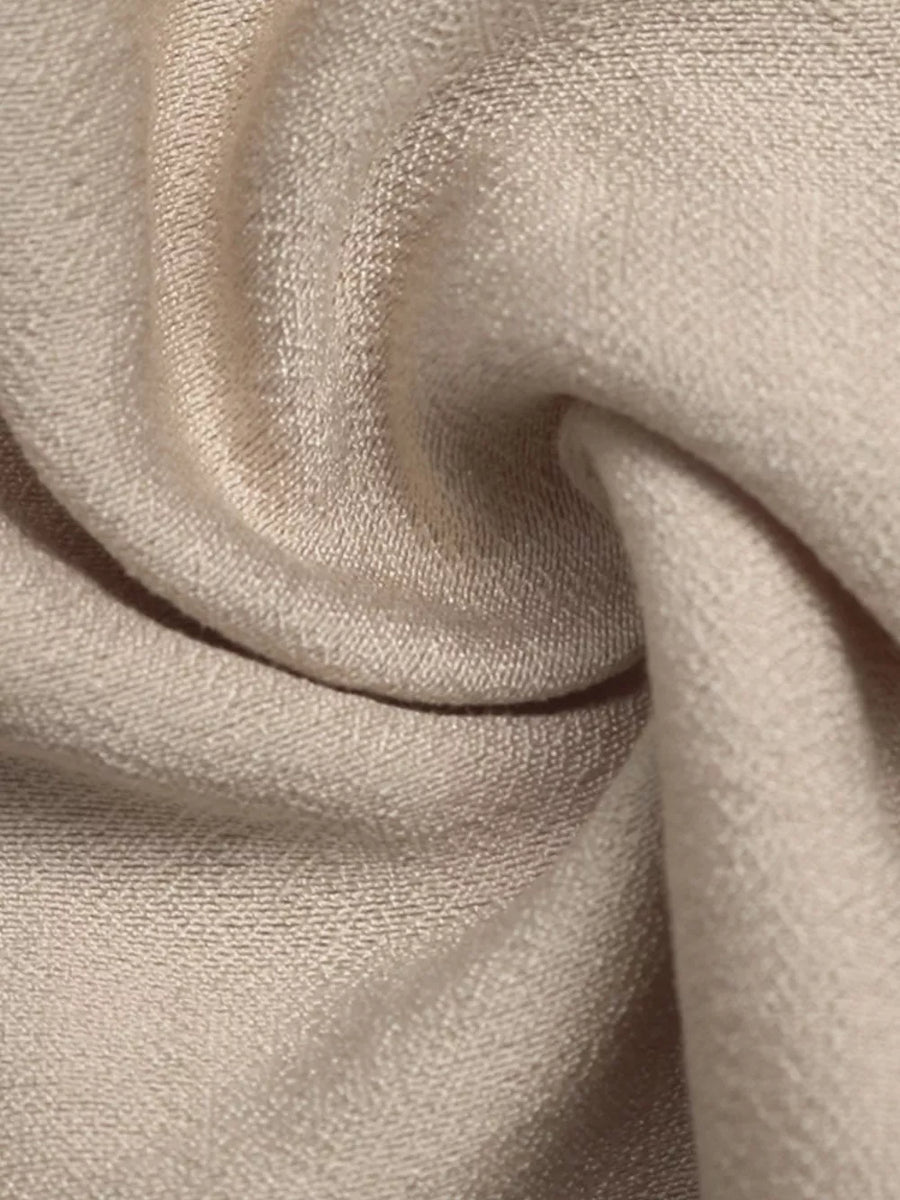 Elegant tied maxi dress in beige with textured fabric and piping detail.