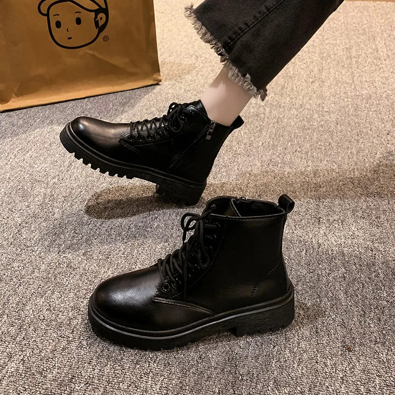 Black glossy leather combat booties with side zip and lace-up front.