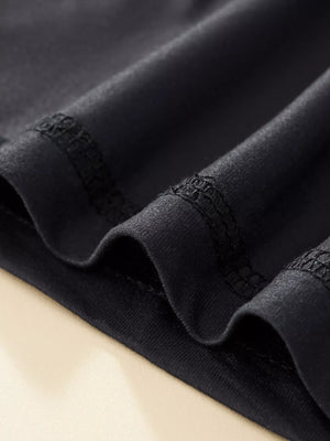 Black baby sleepwear set detail showing fabric texture and stitching.