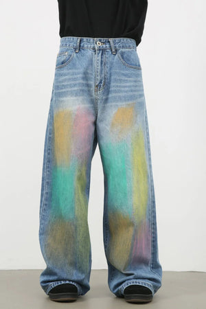 Graffiti wash wide leg denim trousers in medium blue with abstract paint splatters.