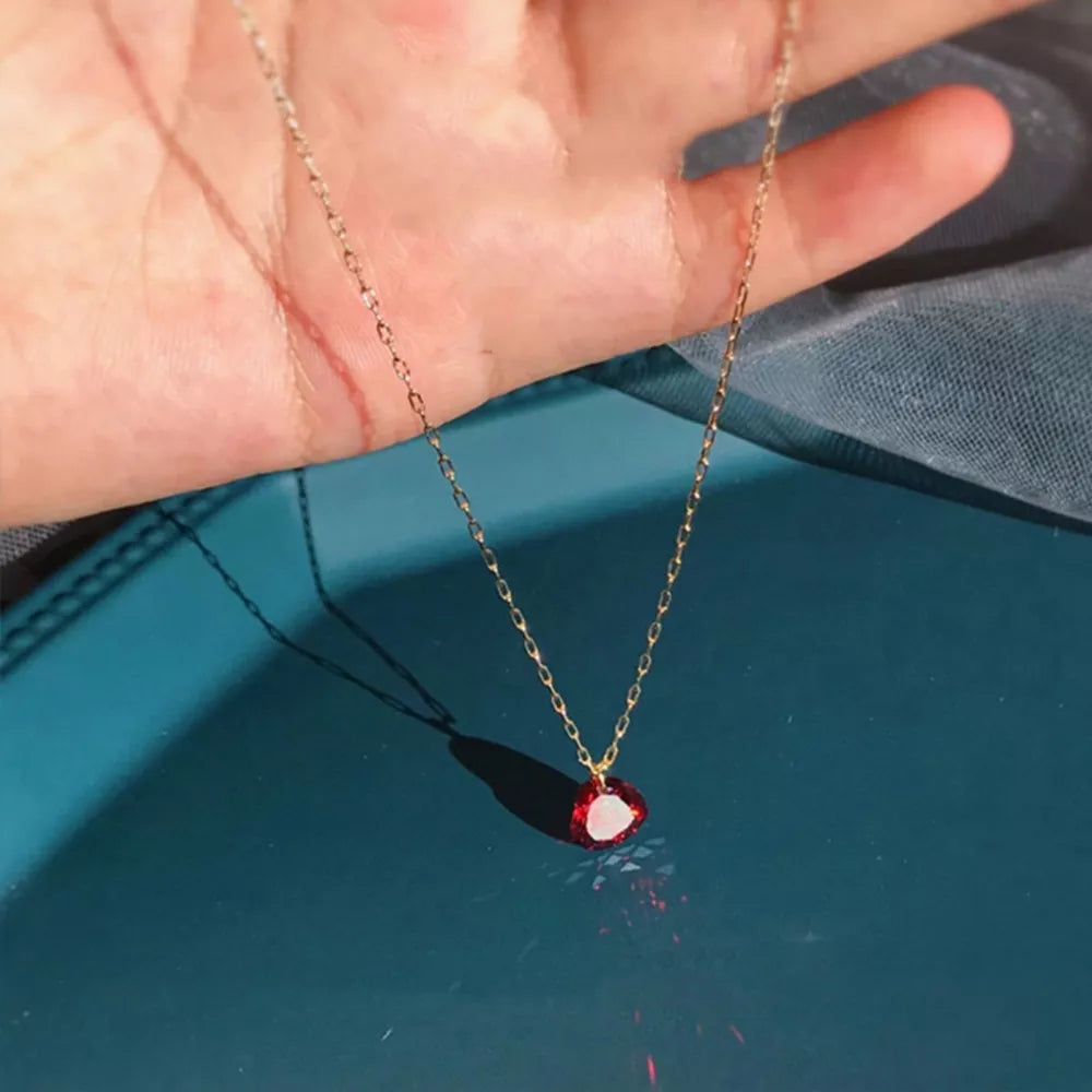 Radiant Heart Zircon Pendant Necklace with delicate gold chain and red gem.
