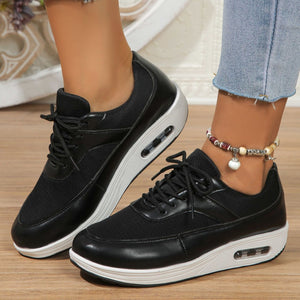 Black lace-up wedge sneakers with breathable mesh and white soles.