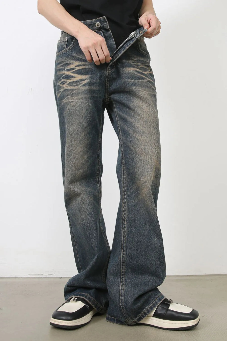 Faded wash wide-leg jeans in medium blue denim with distressed details, shown unzipped.