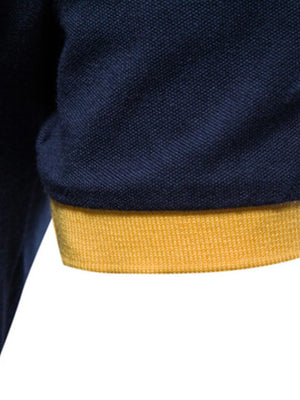 Navy polo shirt with yellow cuff detail.
