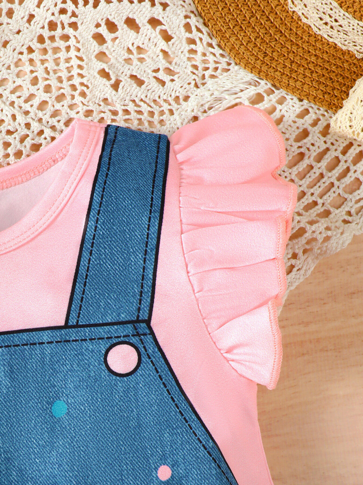 Pink baby dress with denim overalls, polka dots, and ruffle sleeves.