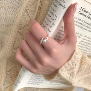 Silver ring featuring bypass design and floral