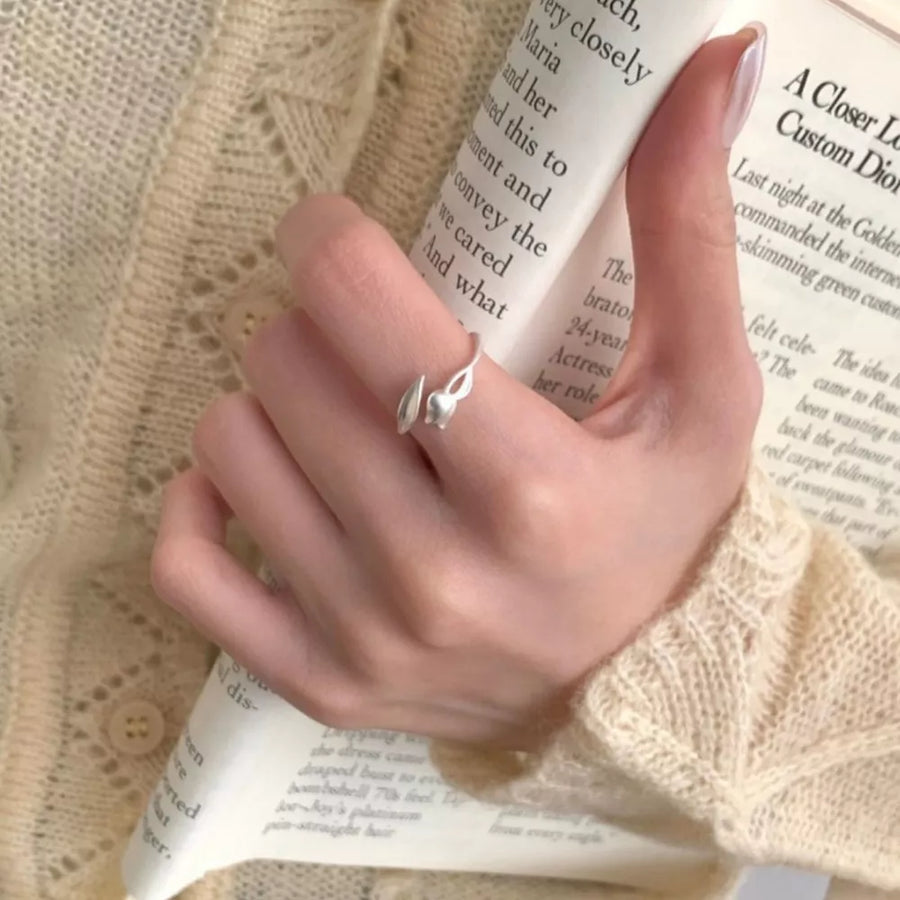 Silver ring featuring bypass design and floral