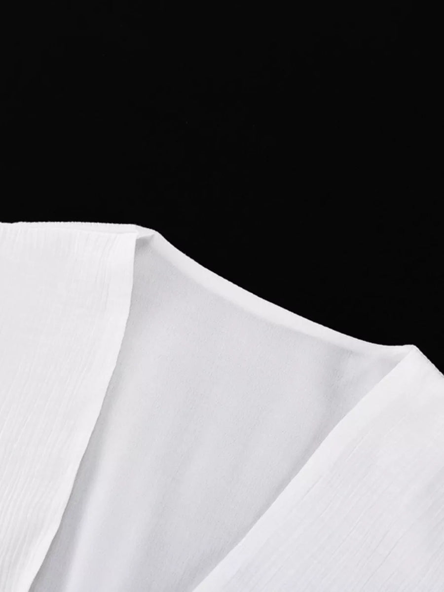 White textured fabric V-neckline blouse with subtle vertical pleats.