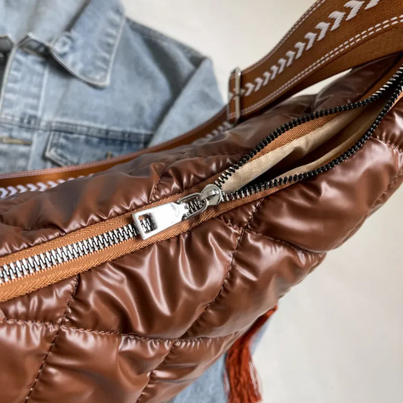 Brown diamond quilt shoulder bag with open zipper and tassel detail.