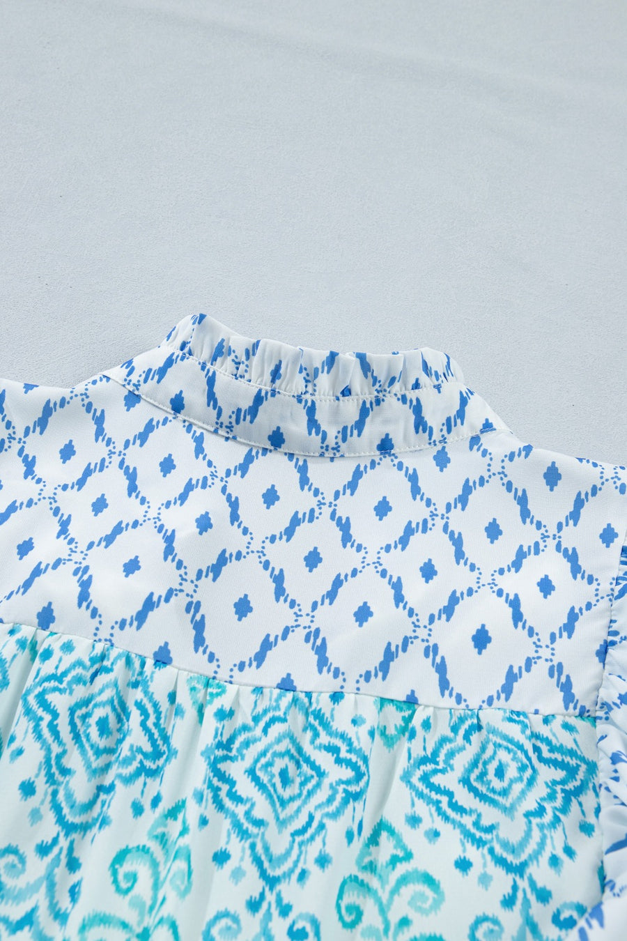 Patchwork mini dress with ruffled mock neck and blue ikat print.