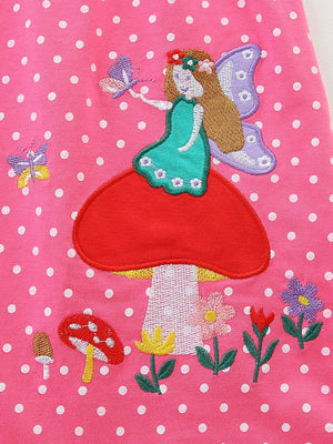 Strawberry polka dot dress with embroidered fairy on mushroom, butterflies, and flowers.