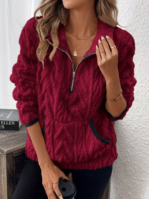 Burgundy sherpa half zip sweatshirt with textured pattern and front pocket.