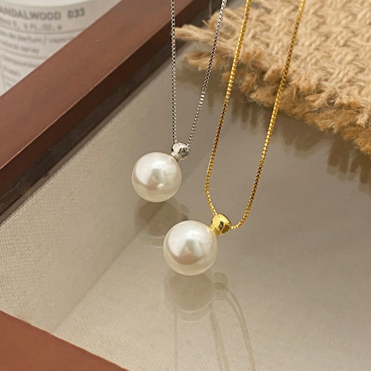 Elegant pearl pendant necklaces in silver and gold with delicate chains.