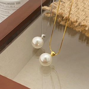 Elegant pearl pendant necklaces in silver and gold with delicate chains.