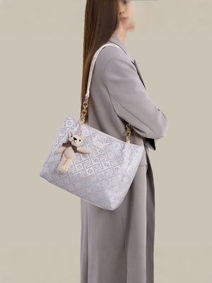light blue handbag featuring detachable charm and geometric