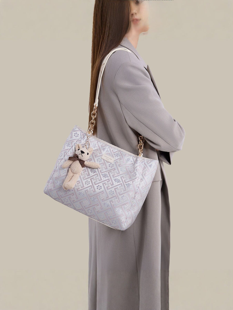 light blue handbag featuring detachable charm and geometric