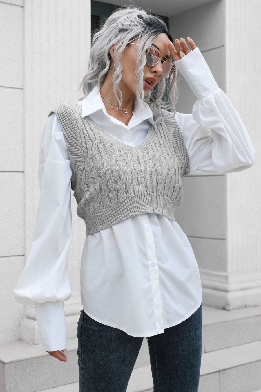 Gray cropped cable knit V-neck vest with a white button-up shirt.