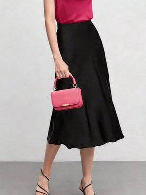 Elegant black A-line midi skirt with a high waist, shown with a pink handbag.