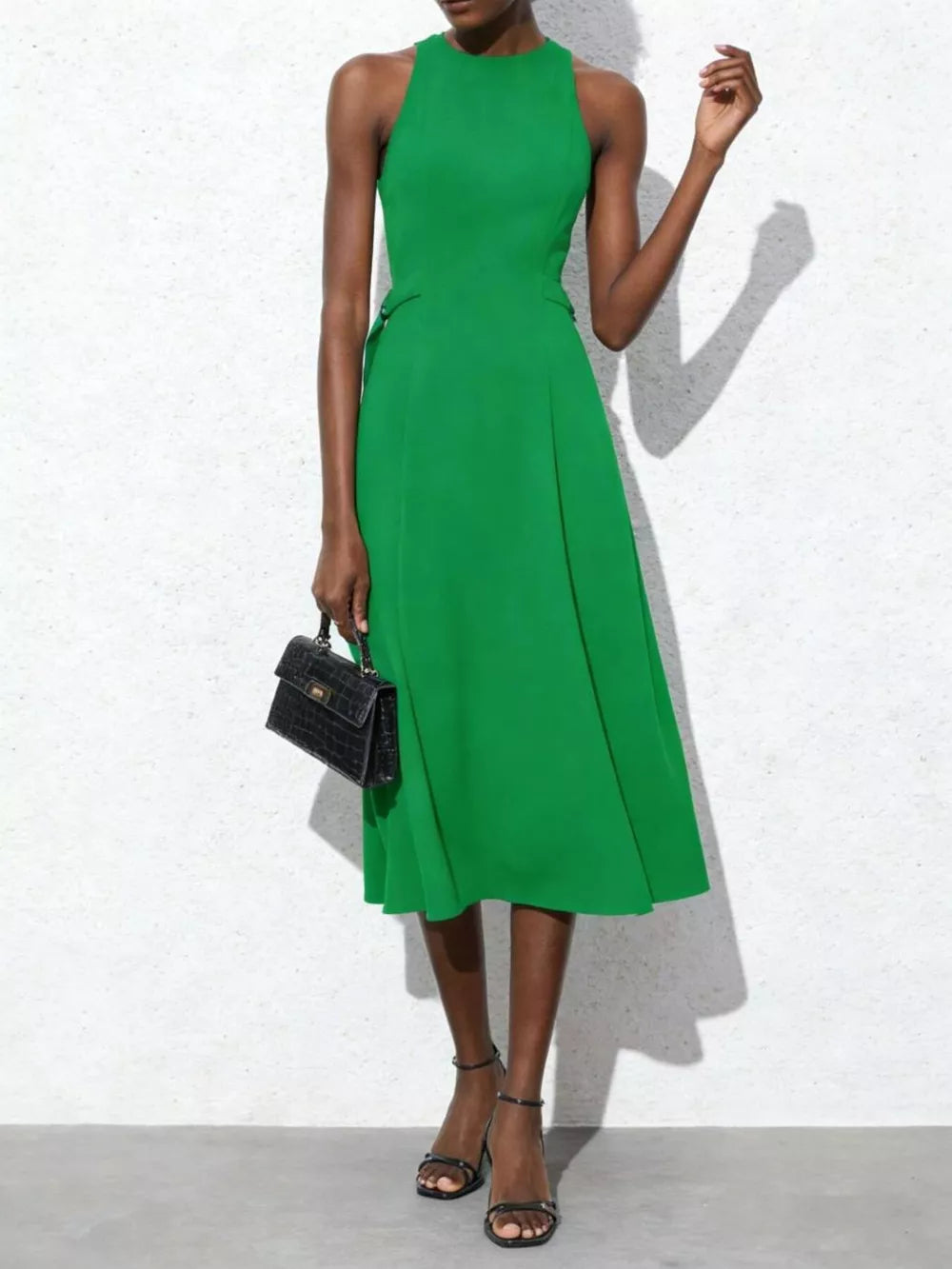 Green midi dress with tie-waist and A-line skirt, sleeveless, high neckline.