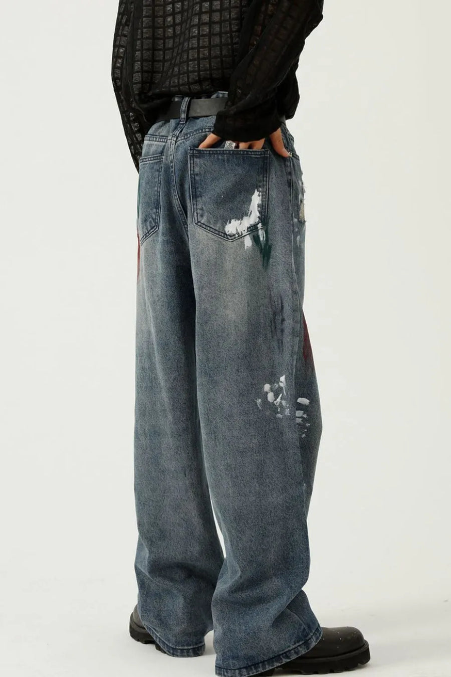 Artisan paint-splatter baggy jeans in medium wash denim with artistic paint details.