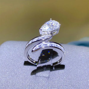 Silver bypass ring with pear cut solitaire and channel set baguette stones.