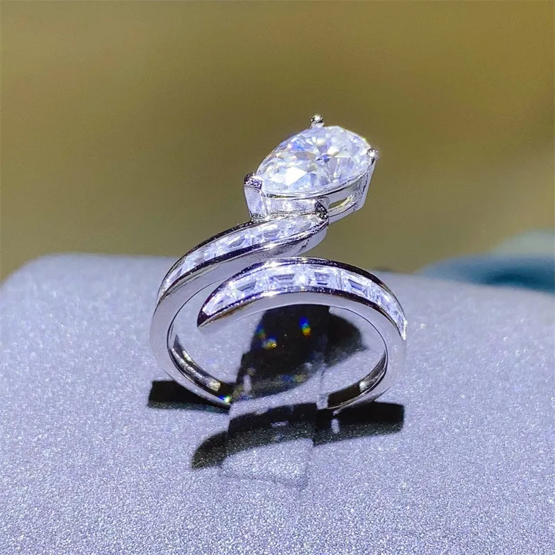 Silver bypass ring with pear cut solitaire and channel set baguette stones.