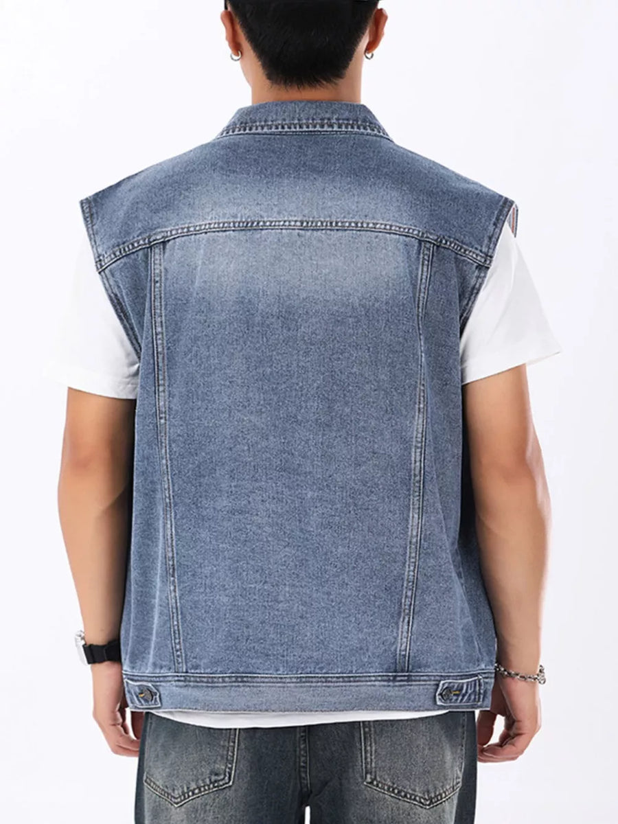 Men's light wash denim vest with collar and button details, worn over a white t-shirt.