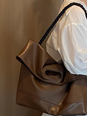Oversized brown PU leather tote bag with rope strap detail.