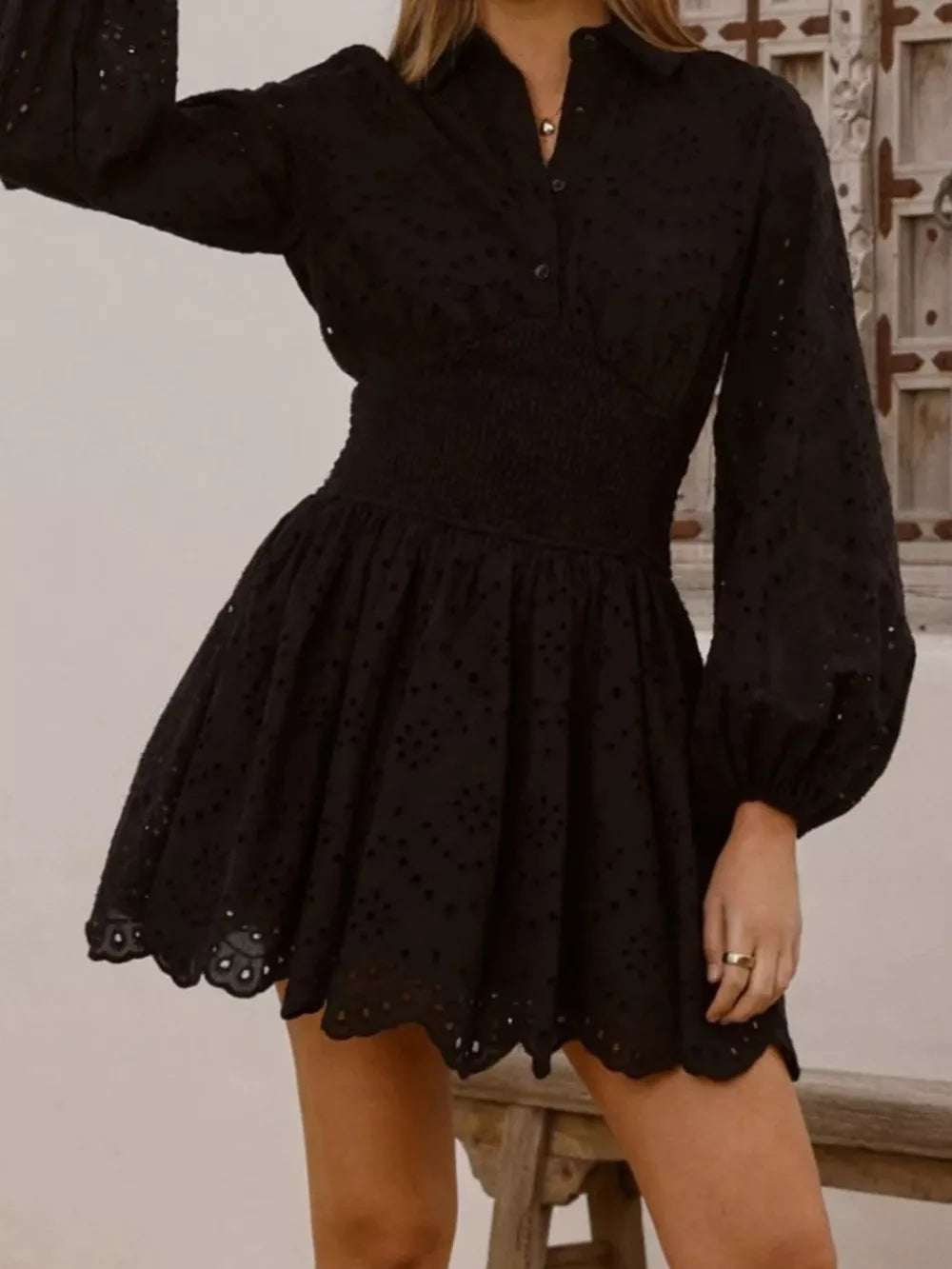 Black eyelet mini dress with balloon sleeves and smocked waist