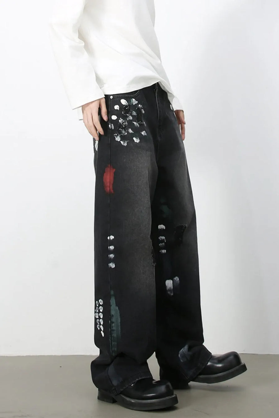Dark wash wide-leg jeans with artistic paint splatters and distressed details.