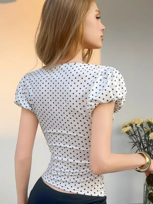 White polka dot ruched t-shirt with puff sleeves and a fitted silhouette.