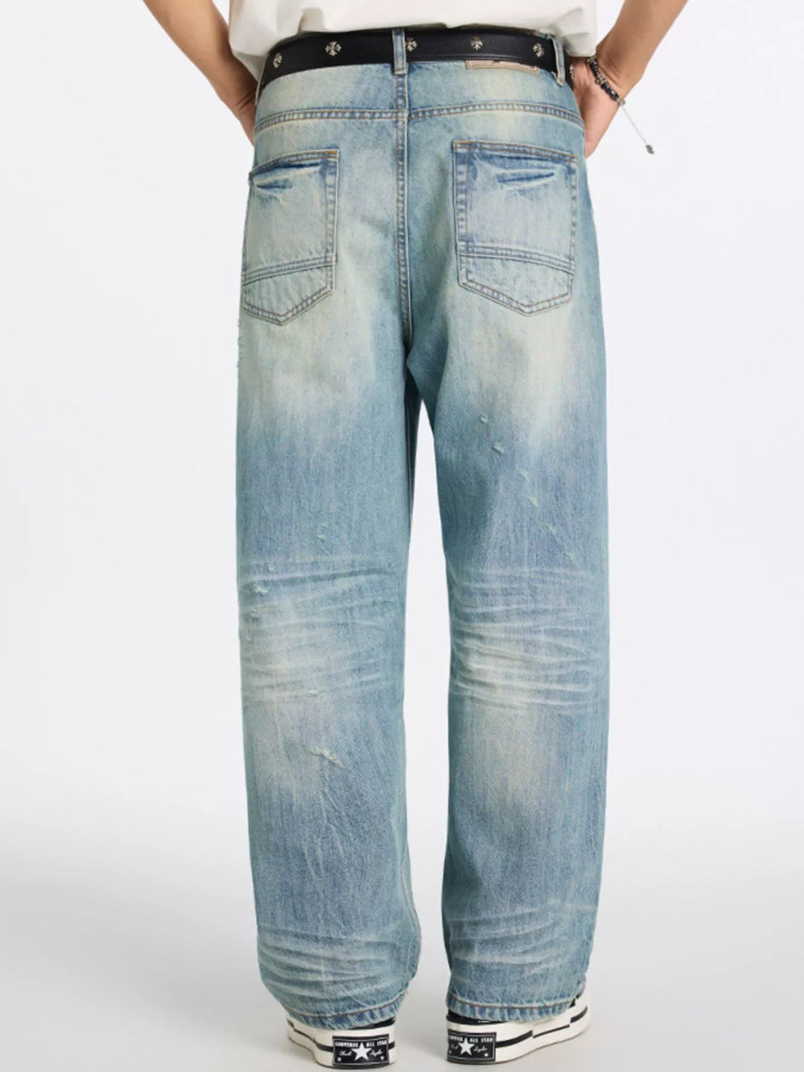 Men's relaxed wide-leg jeans in blue denim with distressed details and a faded wash.
